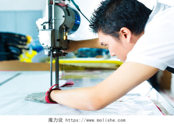在中国的一家纺织厂里他戴着一副手套在工作那是一台用来切割布料的大机器技术工人